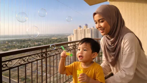 Ibu dan anak kecil bermain buih di balkoni yang selamat dengan kabel invisible grill