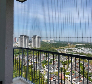 Invisible grill wires across a high-rise balcony overlooking the city