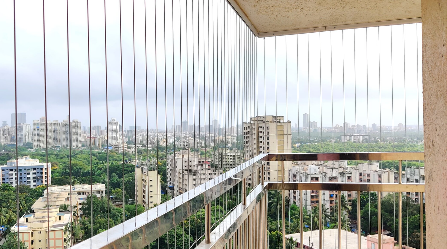 Invisible grill cables on a high-rise balcony, city view