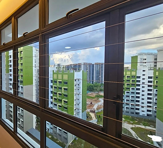 Invisible grill fitted inside timber-framed windows facing green apartment blocks